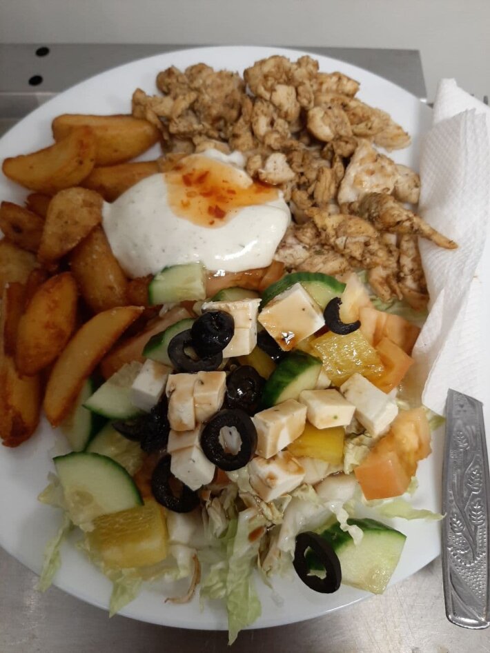 Гирос на тарелке с картофельными дольками и с греческим салатом