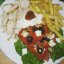 Гирос на тарелке с картофелем фри и греческим салатом